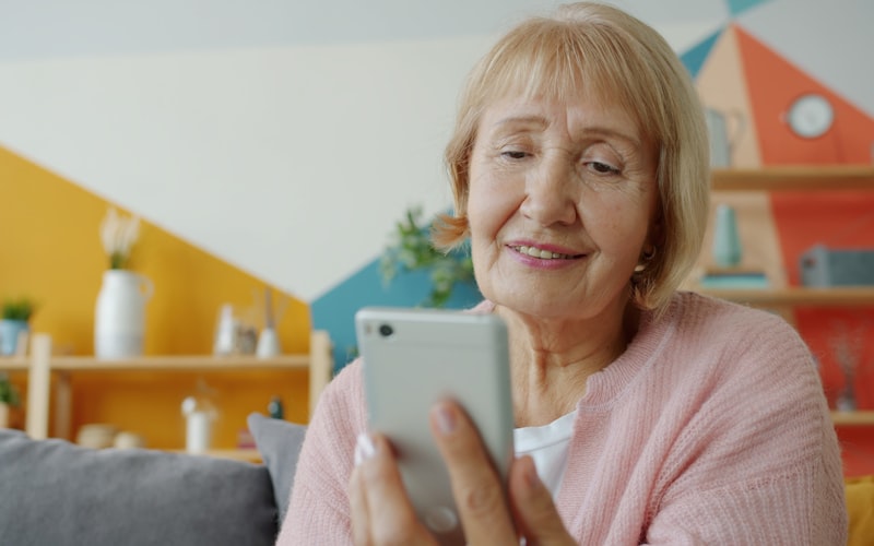 Elderly woman using a simple mobile phone at home — Artfone A400 review